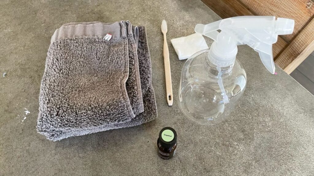 加湿器ではなくアロマウォーターをスプレーボトルに入れ、きれいに畳んだふきんやブラシと一緒に並べたキッチンの掃除グッズ一式